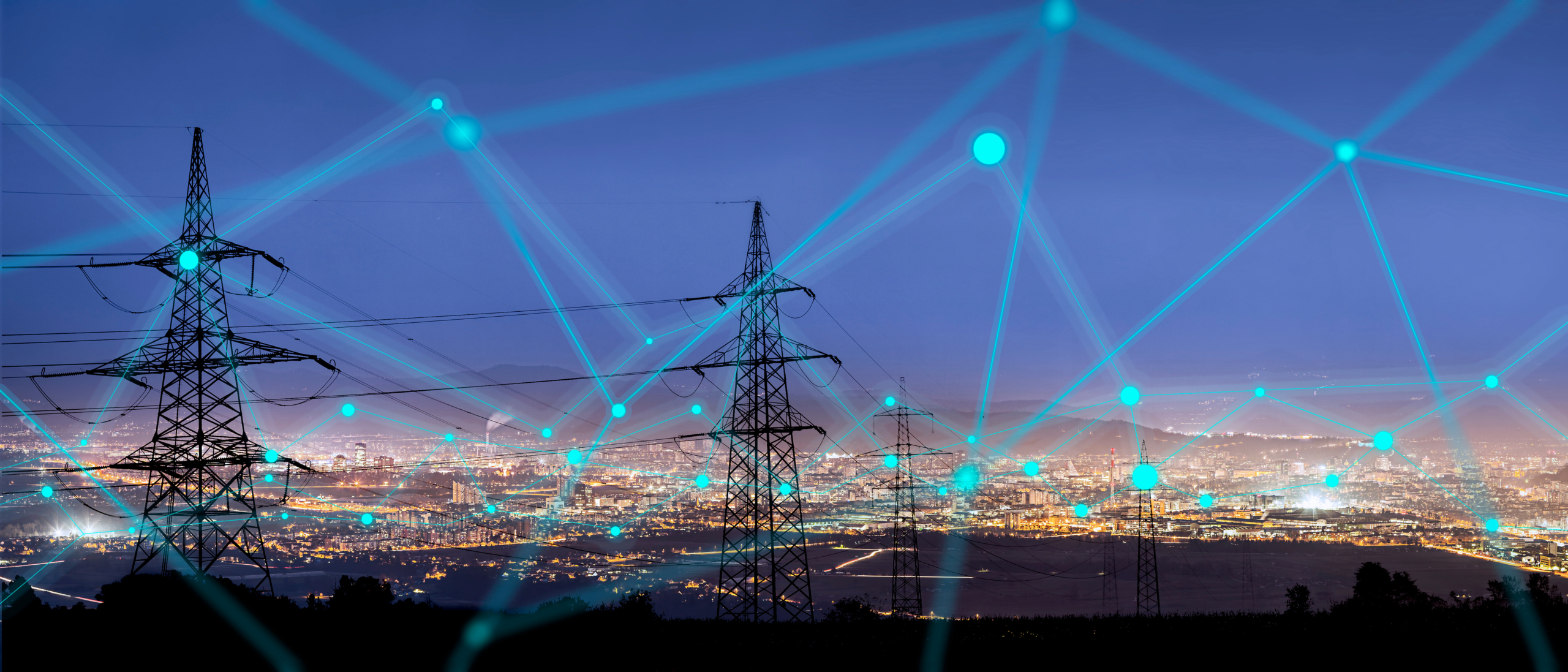 Pylon network over illuminated cityscape at night.