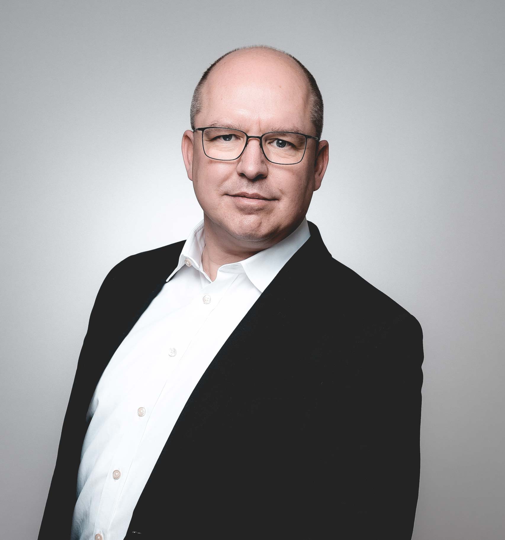 Businessman in suit and glasses posing.