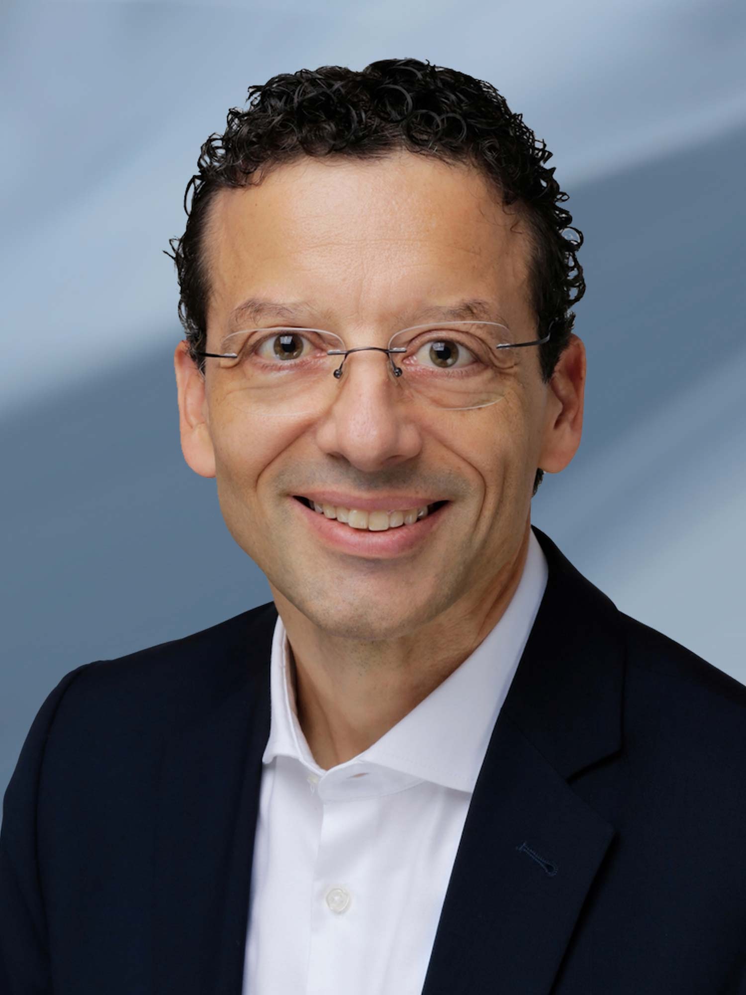 Smiling man with glasses in business attire.