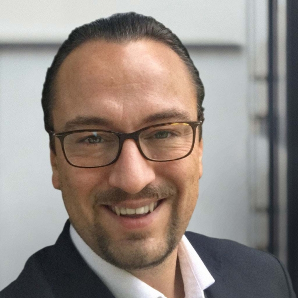 Man smiling in business attire.