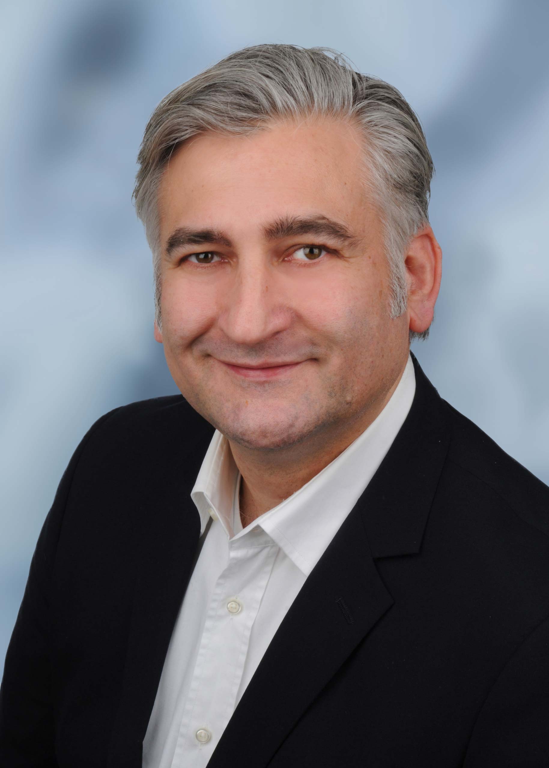 Man in business suit smiling at camera.