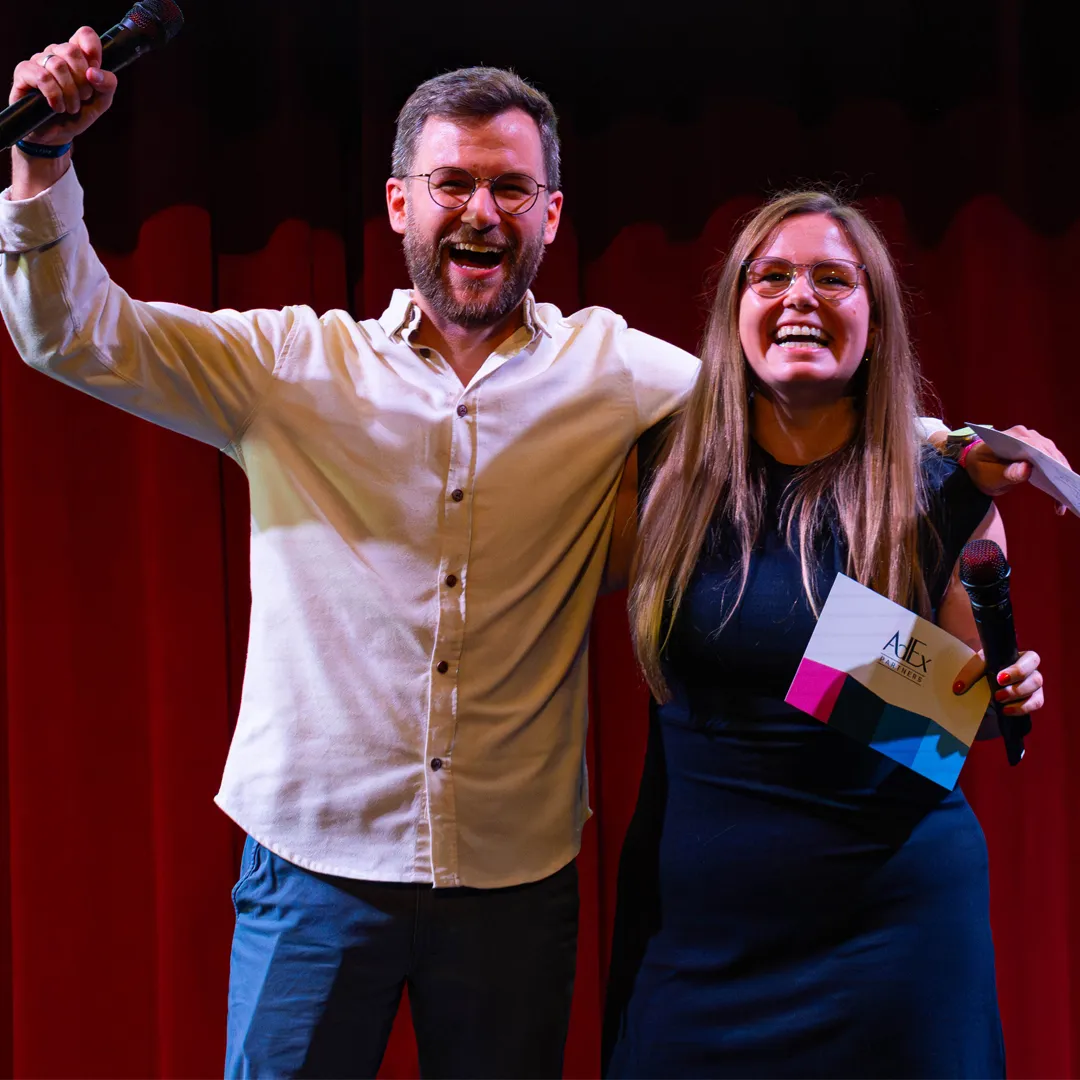Two AdEx Partners employees on stage at an event
